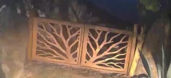 Closed beach gate at night, spotlight on, thin center seam.